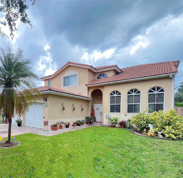 mediterranean / spanish home featuring a front lawn and a garage