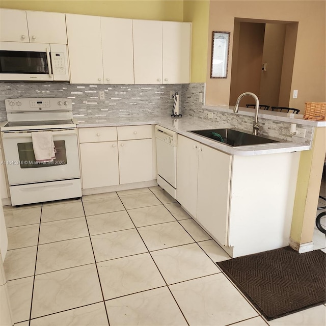 kitchen featuring kitchen peninsula, tasteful backsplash, white appliances, light tile patterned floors, and white cabinets