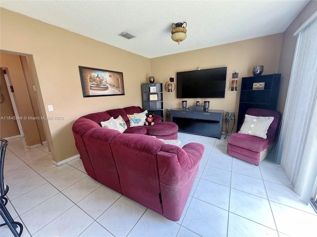 tiled living room featuring a textured ceiling