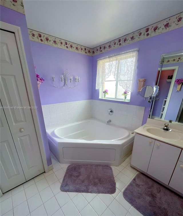 bathroom featuring tile patterned flooring, vanity, and a washtub