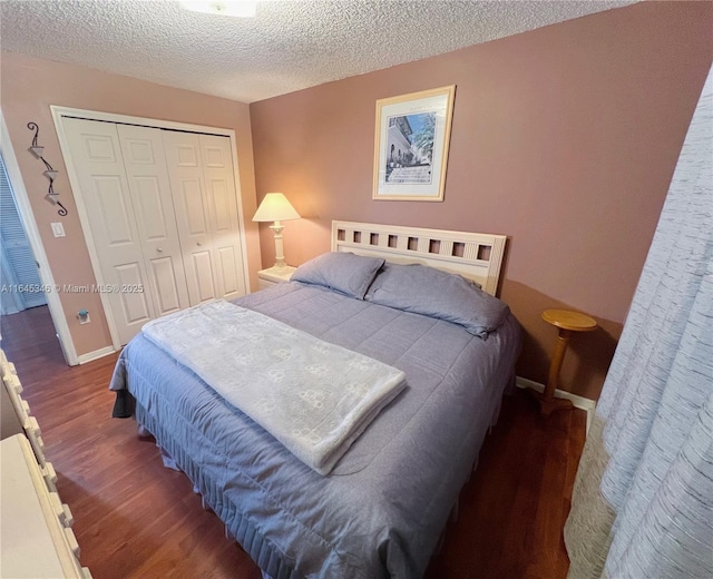 bedroom featuring dark hardwood / wood-style floors, a textured ceiling, and a closet