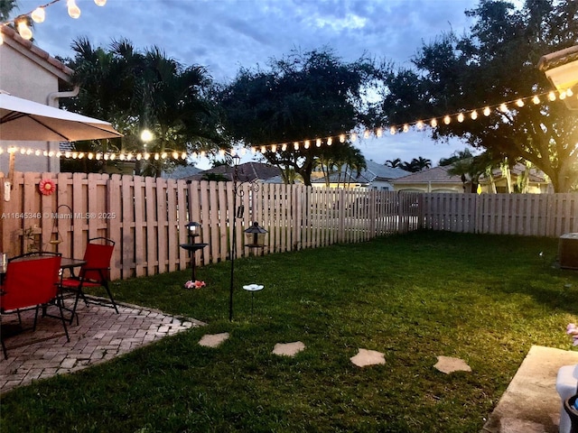 yard at dusk featuring a patio area