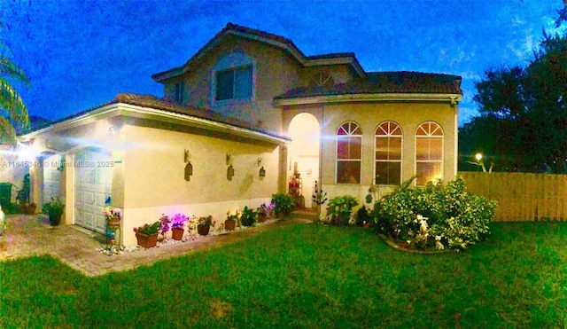 mediterranean / spanish house featuring a garage and a front yard