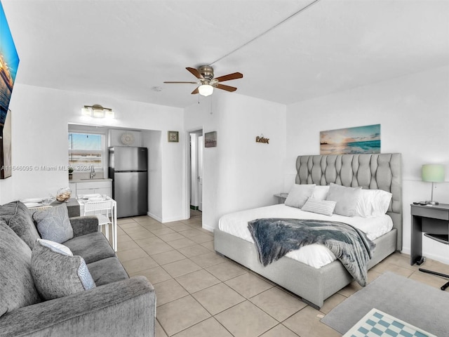 bedroom with ceiling fan, stainless steel refrigerator, sink, and light tile patterned flooring