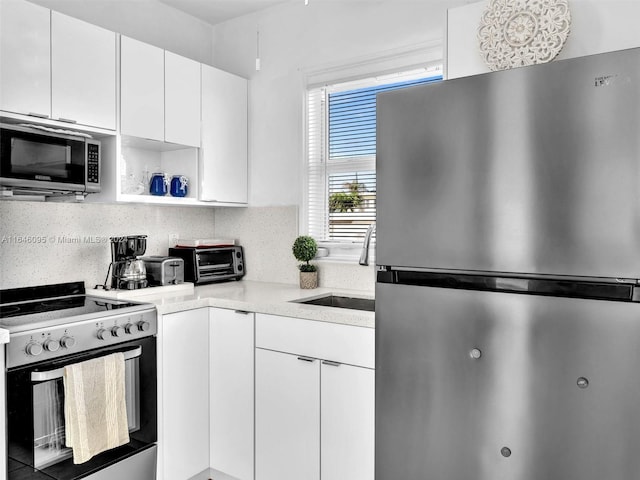 kitchen featuring white cabinets, tasteful backsplash, and stainless steel appliances