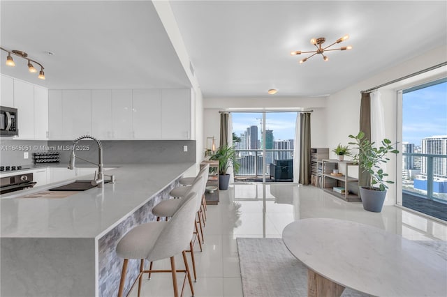 kitchen with stainless steel microwave, light tile patterned floors, and a healthy amount of sunlight
