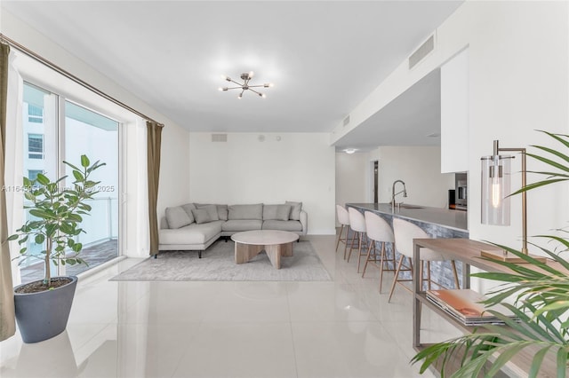 living area with visible vents, a chandelier, and light tile patterned flooring