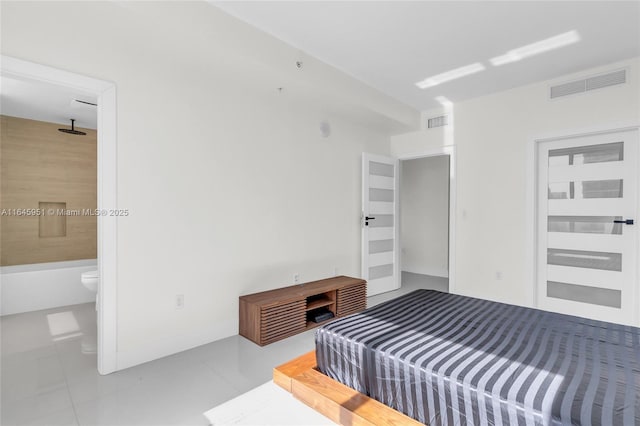 bedroom featuring tile patterned floors, baseboards, visible vents, and connected bathroom
