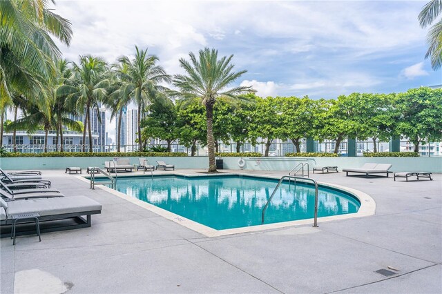 community pool featuring fence and a patio