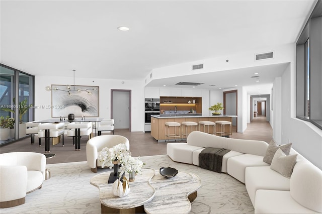 living room featuring a wealth of natural light, sink, and an inviting chandelier