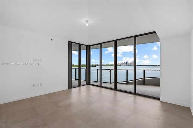 empty room with expansive windows, plenty of natural light, and a water view