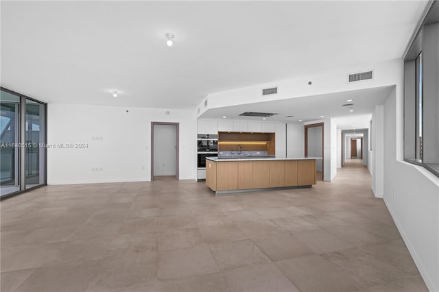 kitchen with plenty of natural light, a kitchen island, and sink