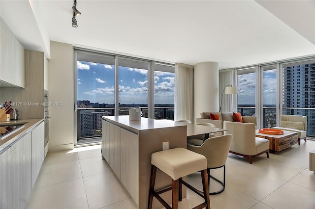 kitchen featuring rail lighting, a center island, light tile patterned flooring, and a healthy amount of sunlight