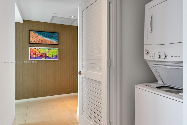 laundry room with stacked washer and dryer and light tile patterned floors