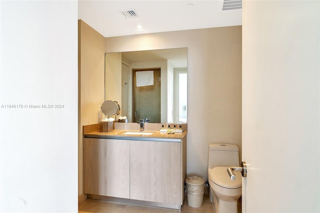 bathroom featuring tile patterned flooring, vanity, and toilet