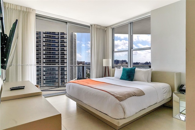 tiled bedroom featuring a wall of windows