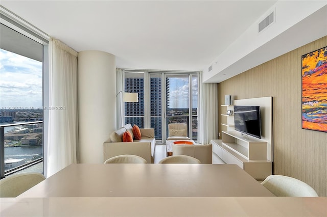 dining area with floor to ceiling windows and a water view