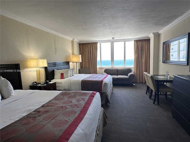 carpeted bedroom featuring ornamental molding, a textured ceiling, and a water view