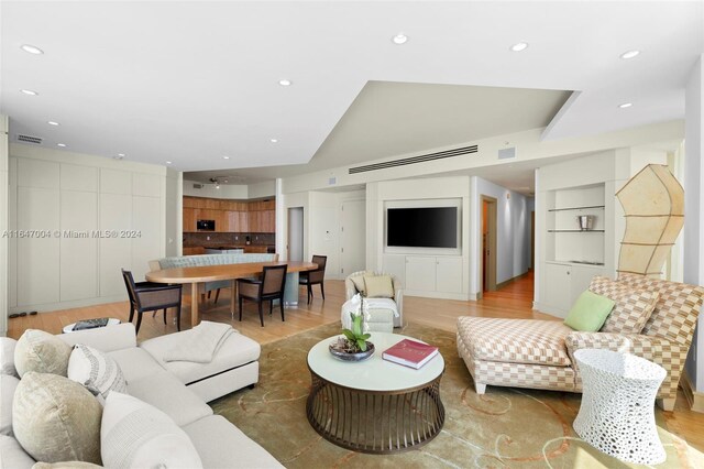 living room featuring light hardwood / wood-style flooring and built in shelves