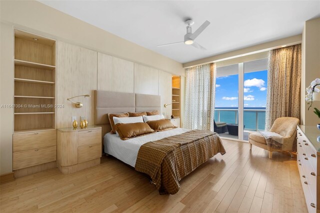 bedroom with ceiling fan, access to outside, light hardwood / wood-style flooring, and a water view