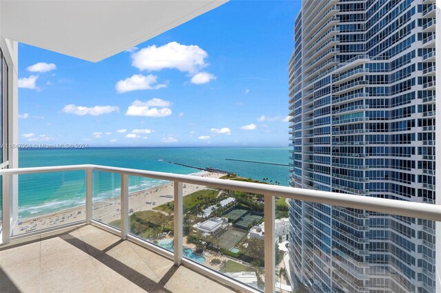 balcony featuring a beach view and a water view