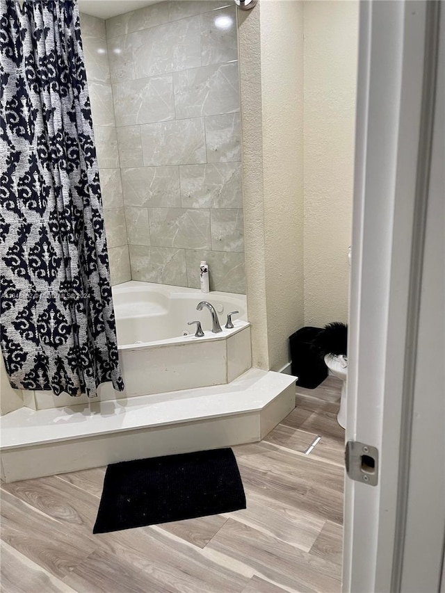 bathroom featuring a textured wall and wood finished floors