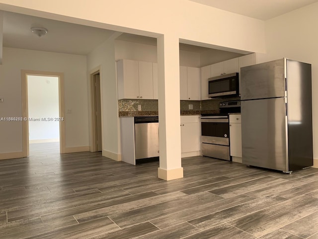 kitchen with backsplash, stainless steel appliances, dark wood-type flooring, and white cabinets