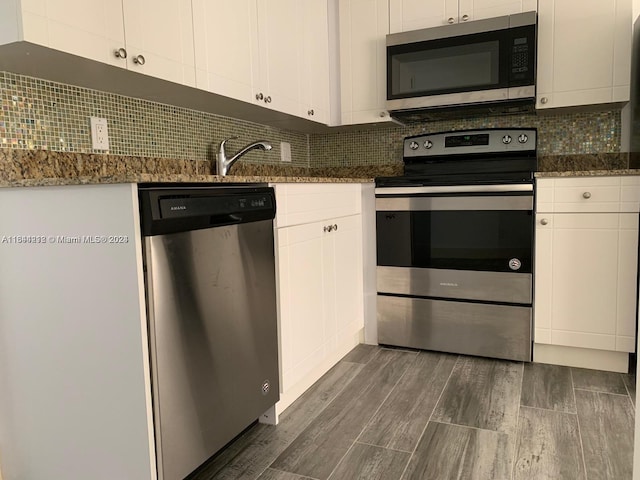 kitchen with white cabinetry, appliances with stainless steel finishes, dark wood-type flooring, and backsplash