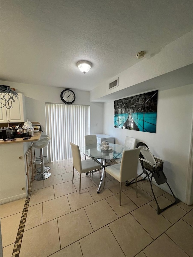 3395 NE 9th St Unit 101, Homestead, FL 33033 - dining area with a textured ceiling and light tile patterned flooring