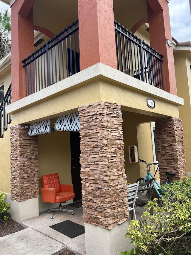 3395 NE 9th St Unit 101, Homestead, FL 33033 - view of property exterior featuring a balcony, stone siding, and stucco siding