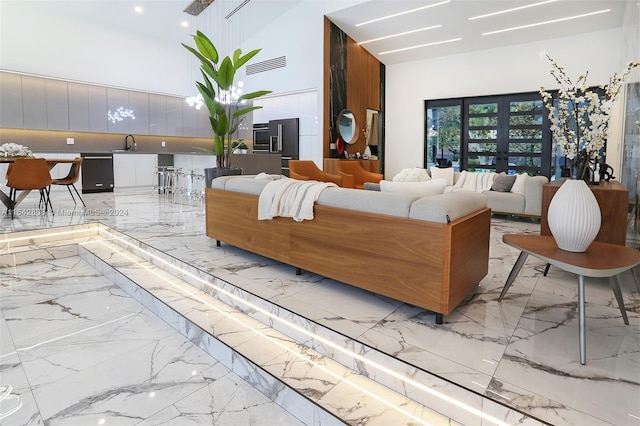 living room featuring a towering ceiling and sink