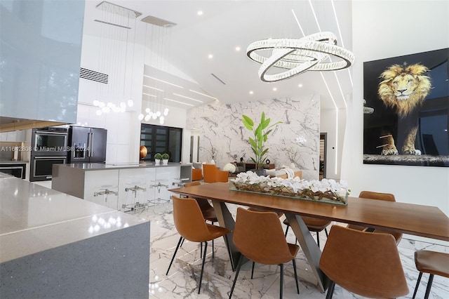 dining room with a high ceiling and a notable chandelier