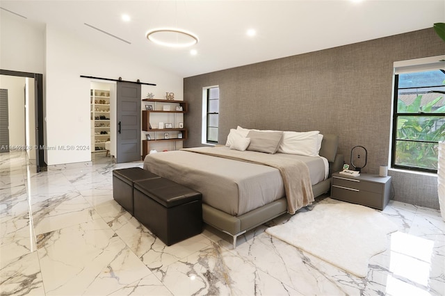 bedroom featuring vaulted ceiling and a barn door