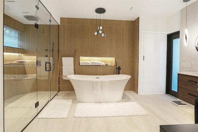 bathroom featuring vanity and independent shower and bath