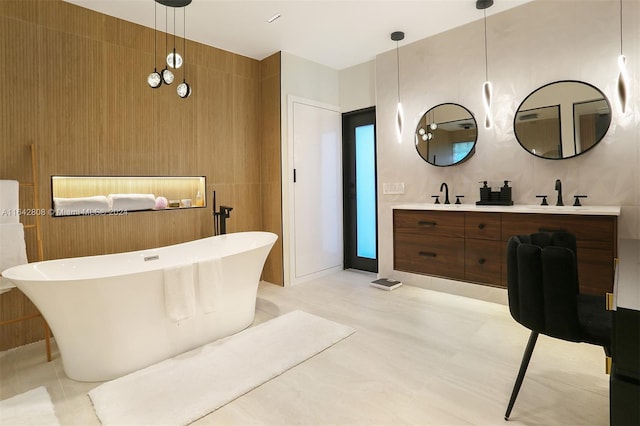 bathroom featuring a bathing tub, vanity, and tile walls