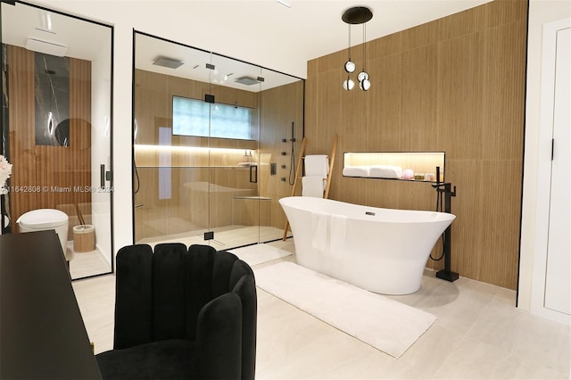 bathroom with tile patterned floors, independent shower and bath, and tile walls