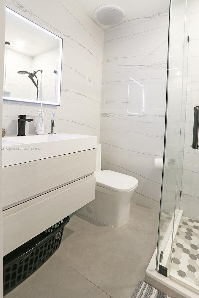 bathroom featuring a shower with door, vanity, and toilet