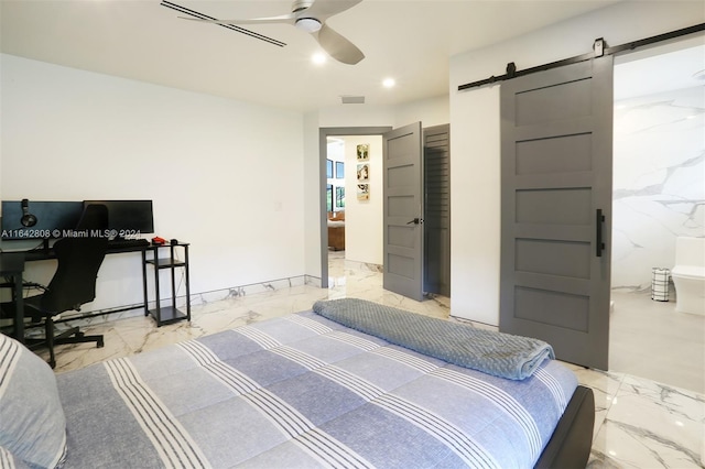 bedroom featuring ensuite bathroom, a barn door, and ceiling fan