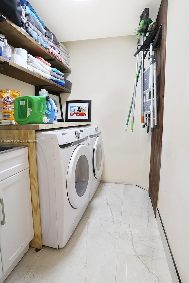 laundry room featuring washer and dryer and cabinets