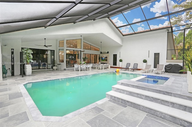 view of swimming pool featuring area for grilling, ceiling fan, and a skylight