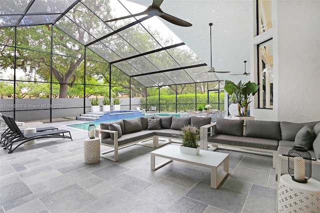 view of patio featuring ceiling fan, glass enclosure, and an outdoor hangout area