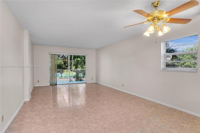 spare room with ceiling fan and light tile patterned floors