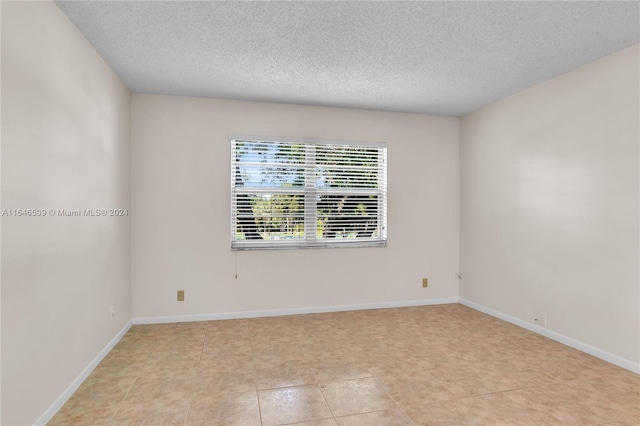 1100 NW 87th Ave Unit 308, Coral Springs, FL 33071 - spare room featuring baseboards and a textured ceiling