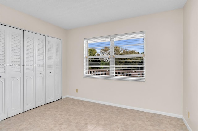 unfurnished bedroom featuring a closet and light tile patterned floors