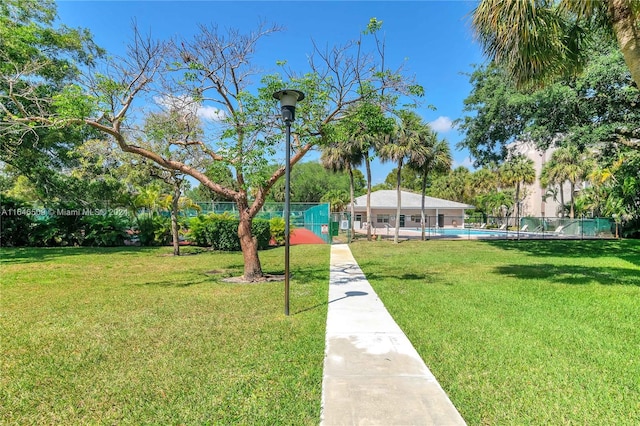 view of property's community with a lawn and a pool