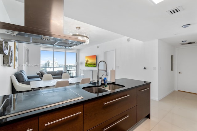 kitchen featuring a sink, visible vents, modern cabinets, dark countertops, and island exhaust hood