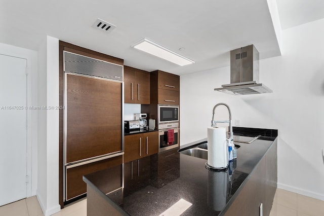 kitchen featuring visible vents, modern cabinets, built in appliances, a peninsula, and island exhaust hood