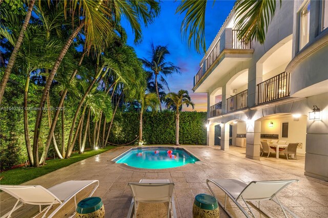 pool at dusk with a patio