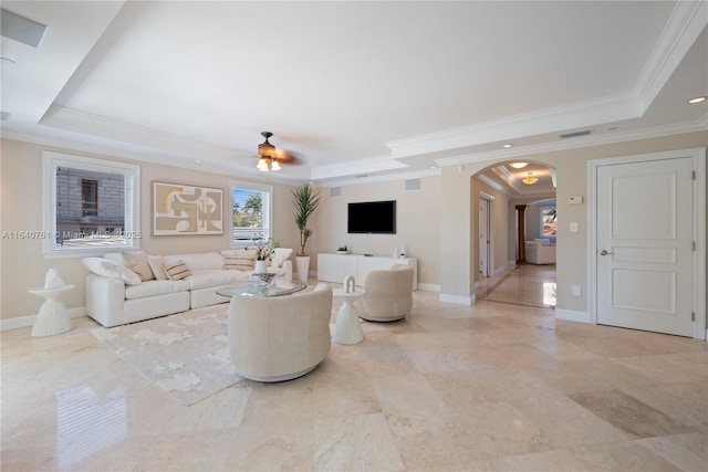 living room with crown molding, ceiling fan, and a tray ceiling