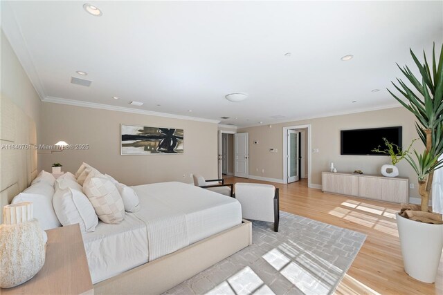 bedroom featuring crown molding and light hardwood / wood-style floors